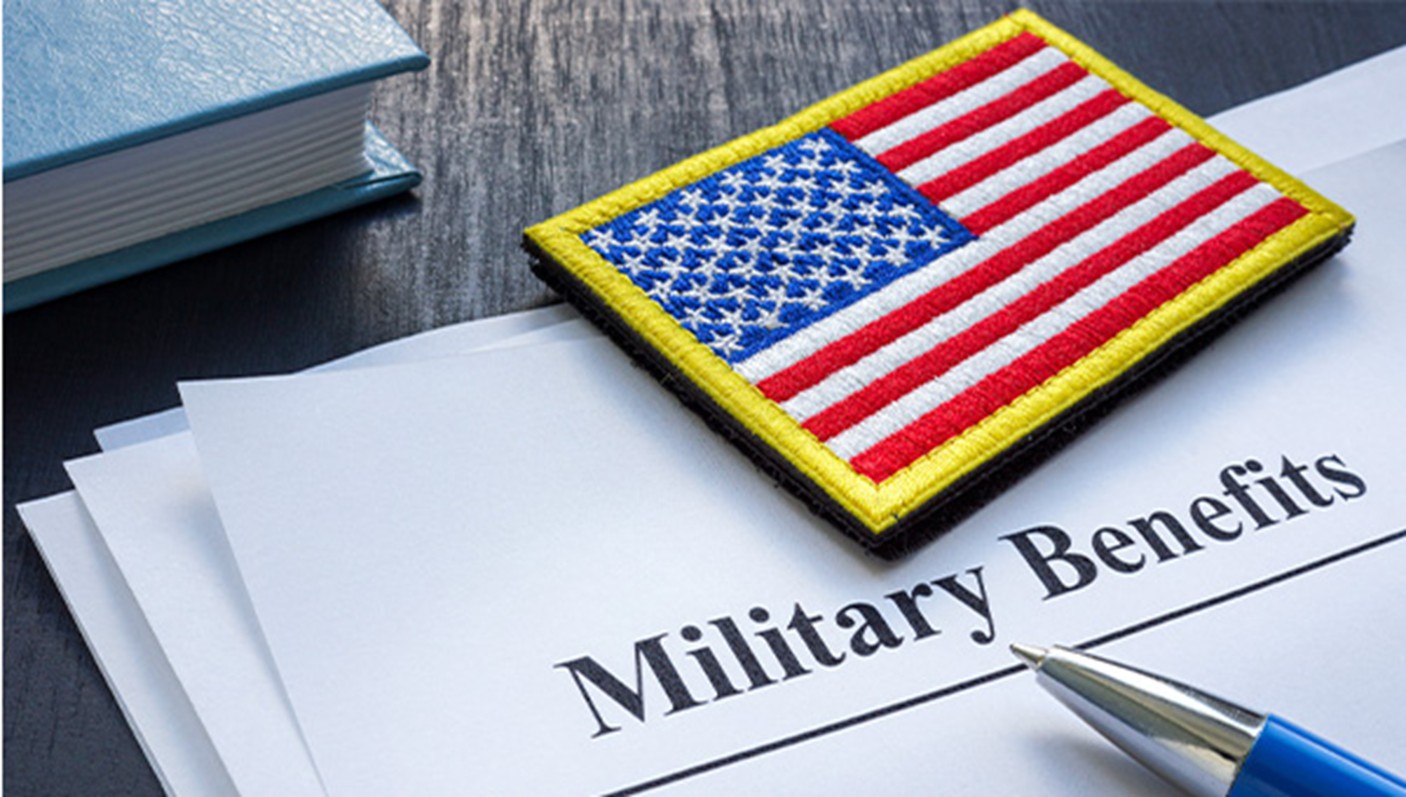 An American flag patch lays on top of paperwork regarding military benefits.