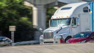 A picture of a tractor trailer driving along a roadway.