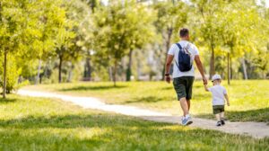 A picture of a dad walking with his child.