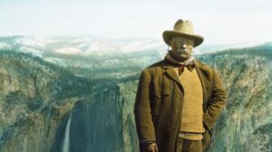 A picture of Theodore Roosevelt standing in front of Yosemite Falls.