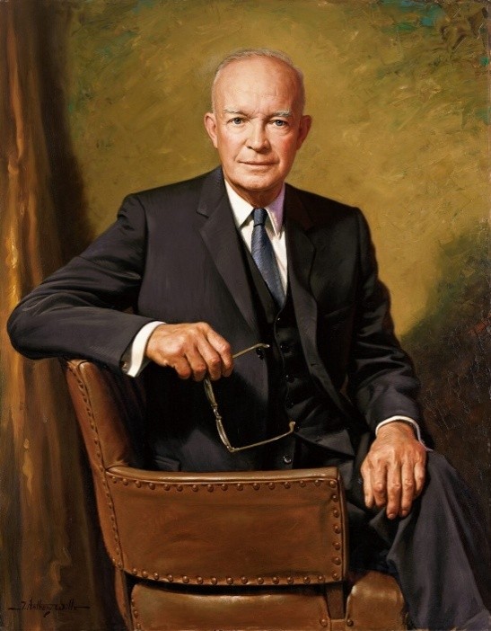 A portrait of Dwight D. Eisenhower sitting on a chair.