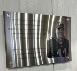 A picture of a plaque dedicating the Robert “Bobby’ Robinson production bay at the Nucor facility in West Hazleton.