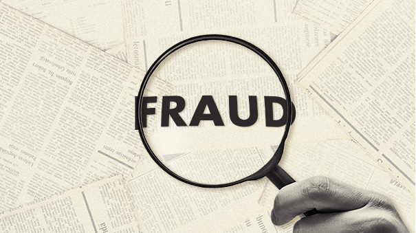 magnifying glass zooming in on the word “fraud.”