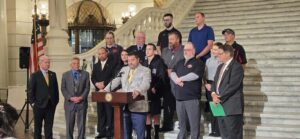 A picture of Sen. Argall joining state legislators, firefighters, and volunteers on the steps in the rotunda in the State Capitol in Harrisburg.